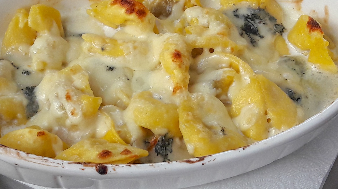 Ultra close-up macro of bubbling creamy garlic parmesan tortellini skillet